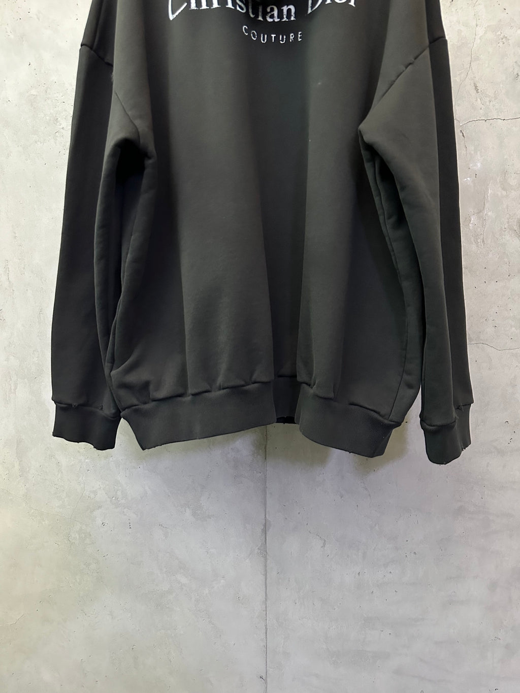 Black Dior hooded sweatshirt with ribbed hem and long sleeves.