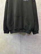 Black Dior hooded sweatshirt with kangaroo pocket detail on front.