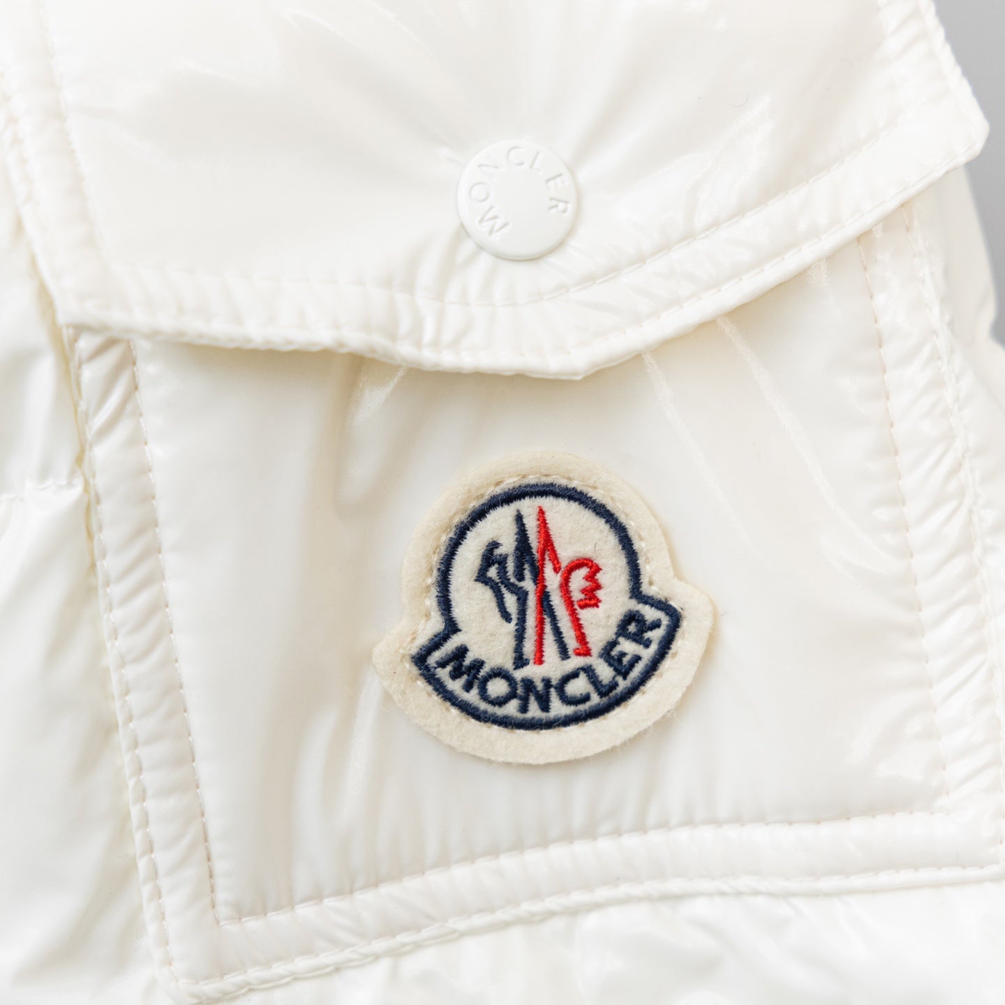 Moncler long white puffer jacket, close-up round logo patch on front panel