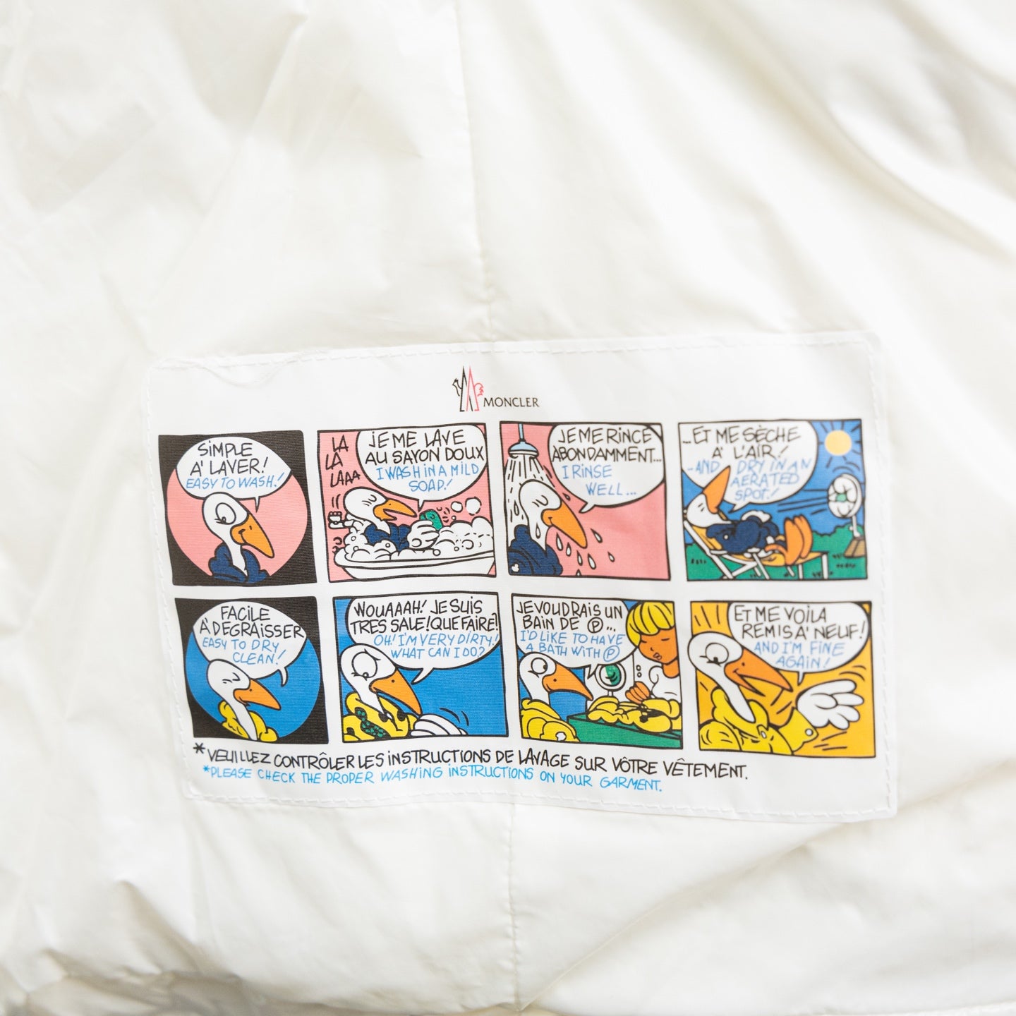 Moncler long puffer jacket, white interior care instructions label with icons