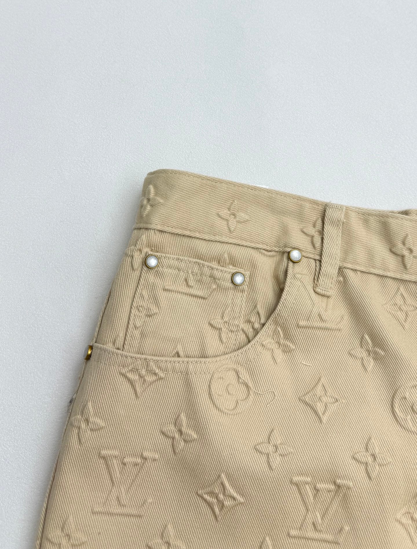 Beige Louis Vuitton monogram pants with curved front pocket and snap buttons