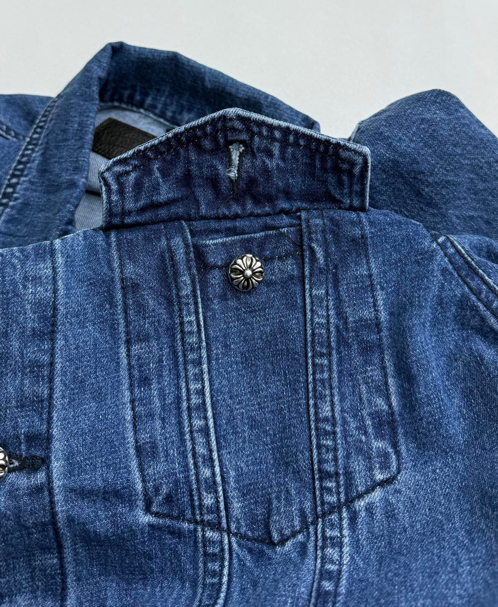 Denim jacket shoulder and chest with decorative button detail on yoke