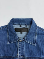 Denim jacket collar with dark logo patch and buttoned placket