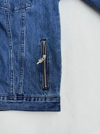 Blue denim jacket sleeve panel with vertical zipper pocket and metal pulls