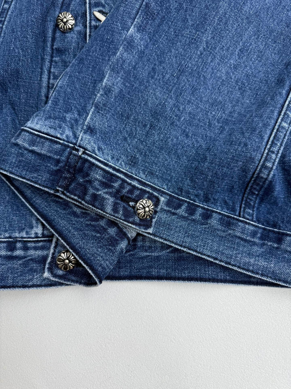 Denim jacket cuffs and chest area with snap-button details