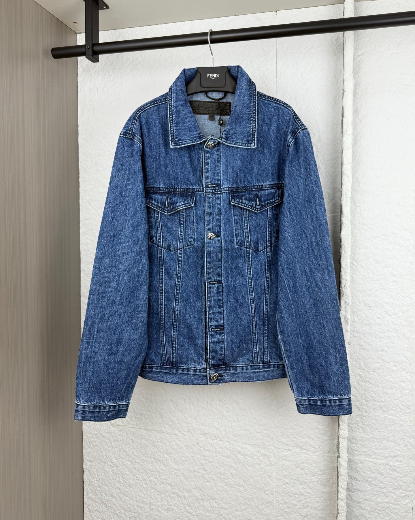 Blue denim jacket with button front, pointed collar, and chest pockets