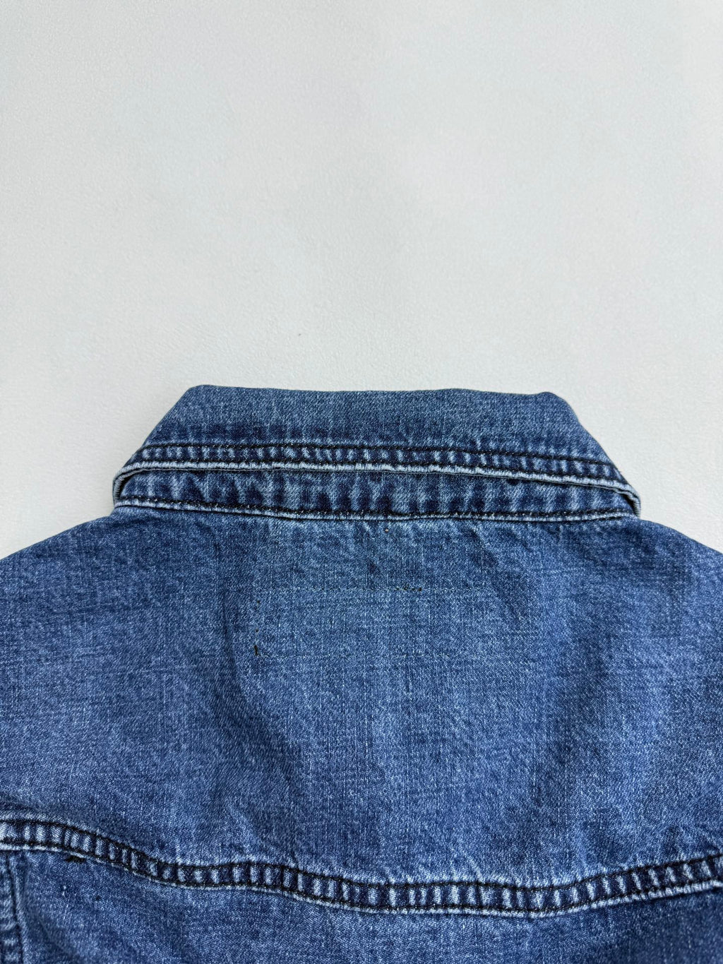 Denim jacket back yoke with curved seam and collar stitching