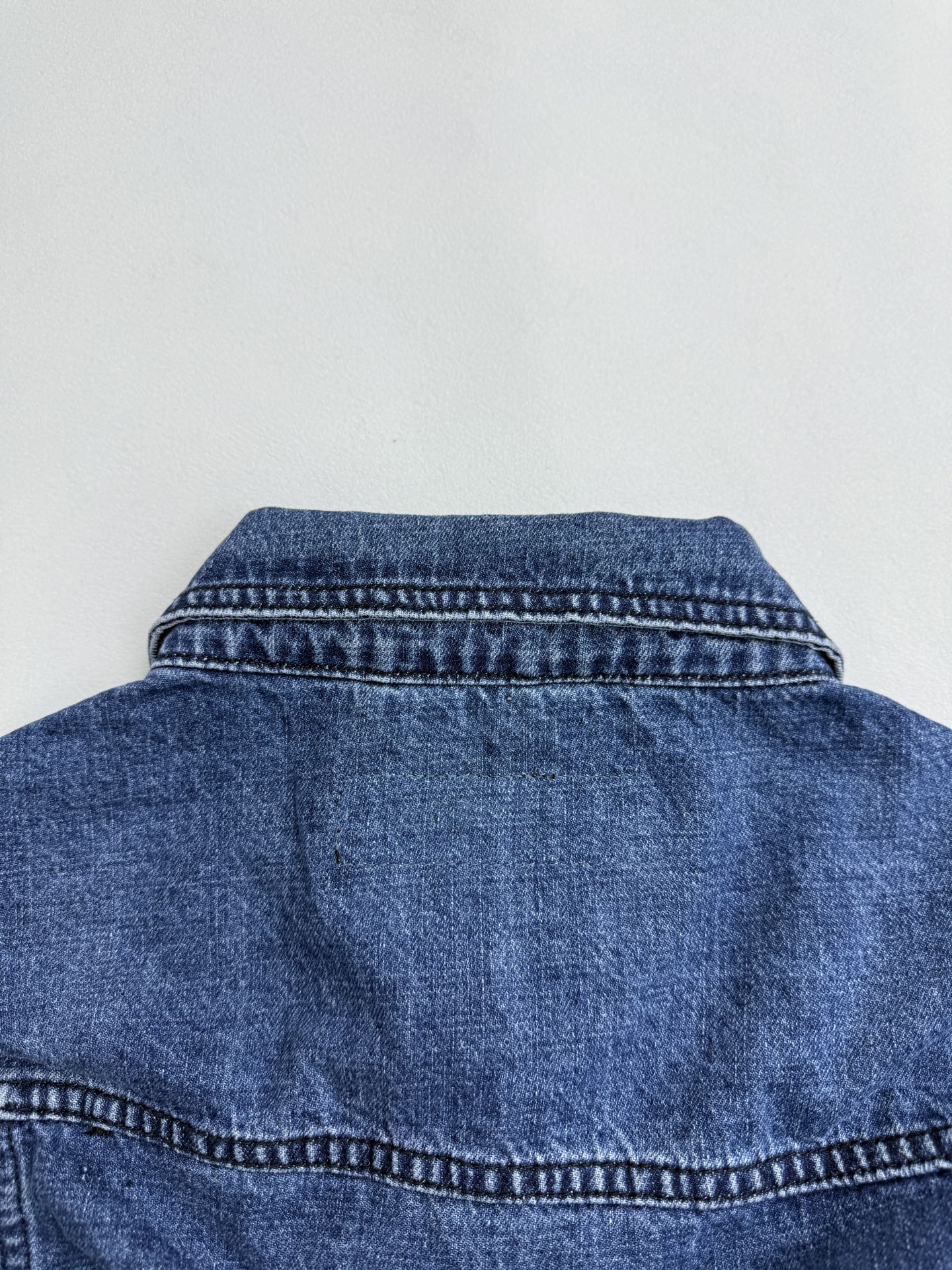 Denim jacket back yoke with curved seam and collar stitching