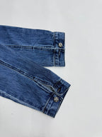 Denim jacket cuff with button closure and stitched sleeve seam