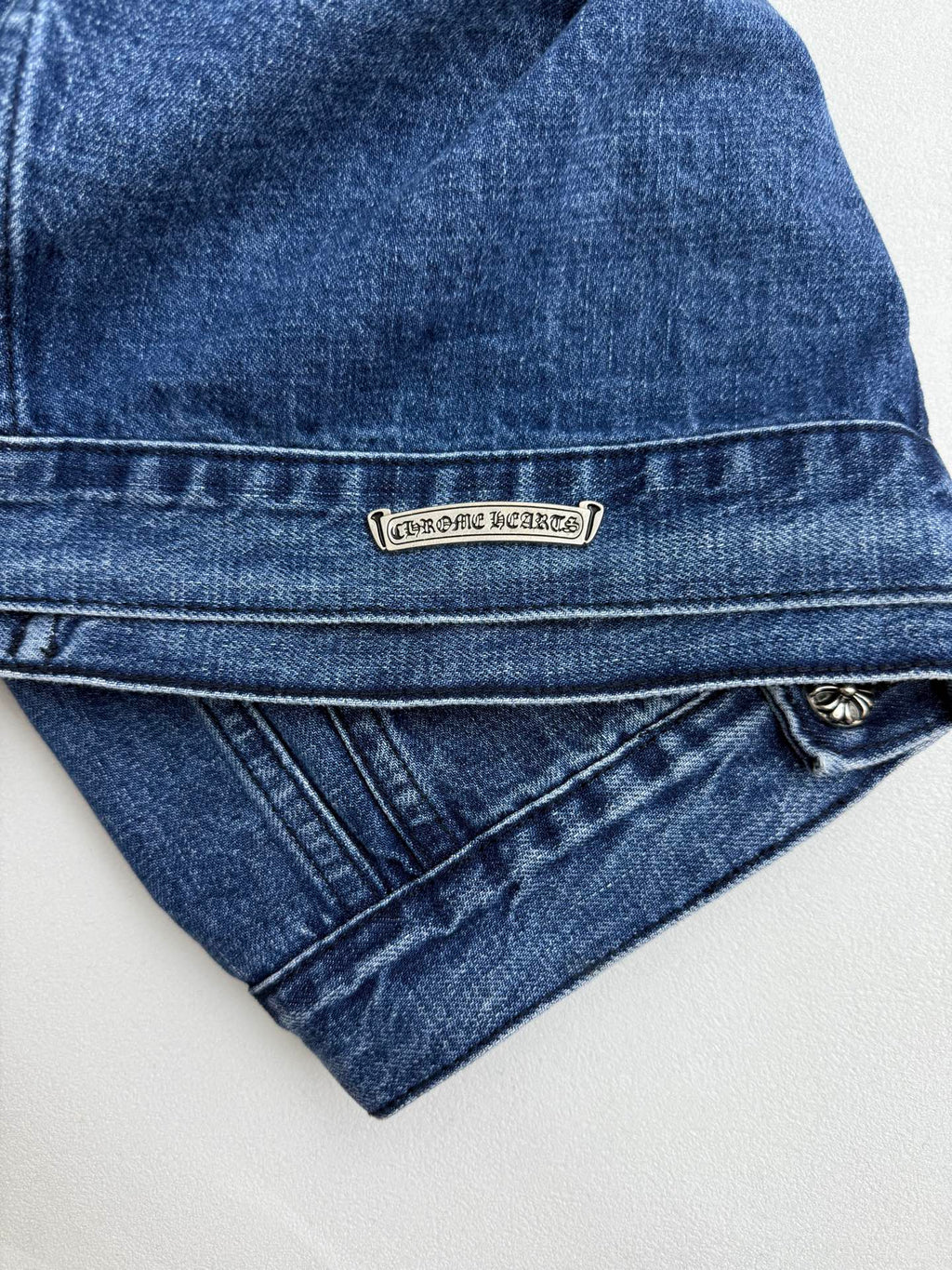 Denim jacket waistband label plate and diagonal seam detail