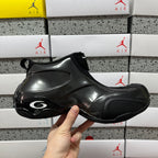 Unisex black glossy sneakers with circular air-style detail on toe
