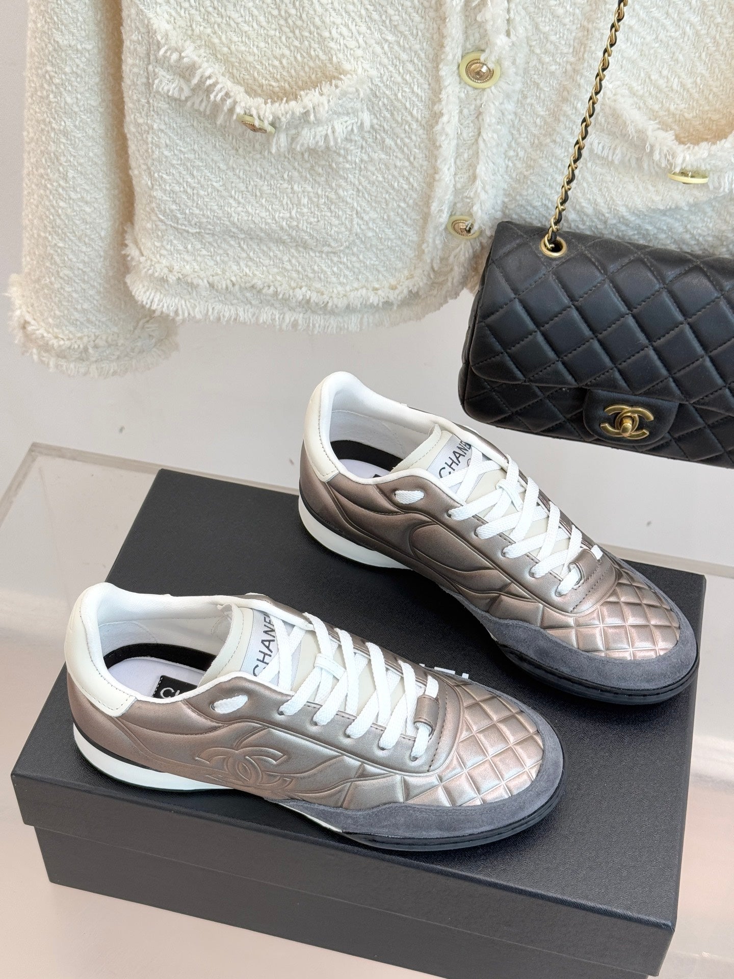 Ladies sneakers in metallic beige and gray with white laces, shown at angle