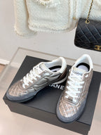 Pair of ladies sneakers on box: metallic beige and silver-gray with white laces