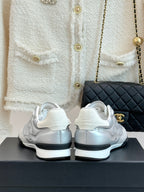Chanel ladies white sneakers rear view with sculpted heel and dark sole trim