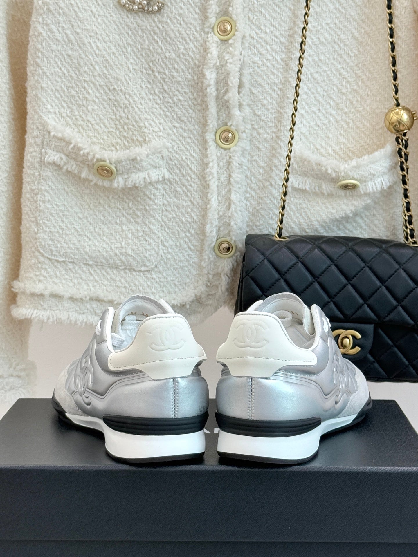 Chanel ladies white sneakers rear view with sculpted heel and dark sole trim