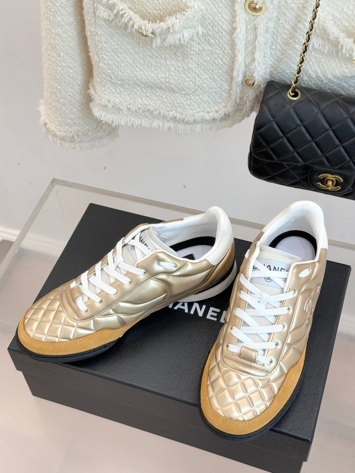 Chanel low-top sneaker pair in gold leather with white lace-up front