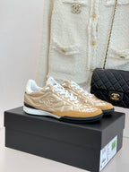 Chanel low-top sneaker in gold with white laces and quilted texture