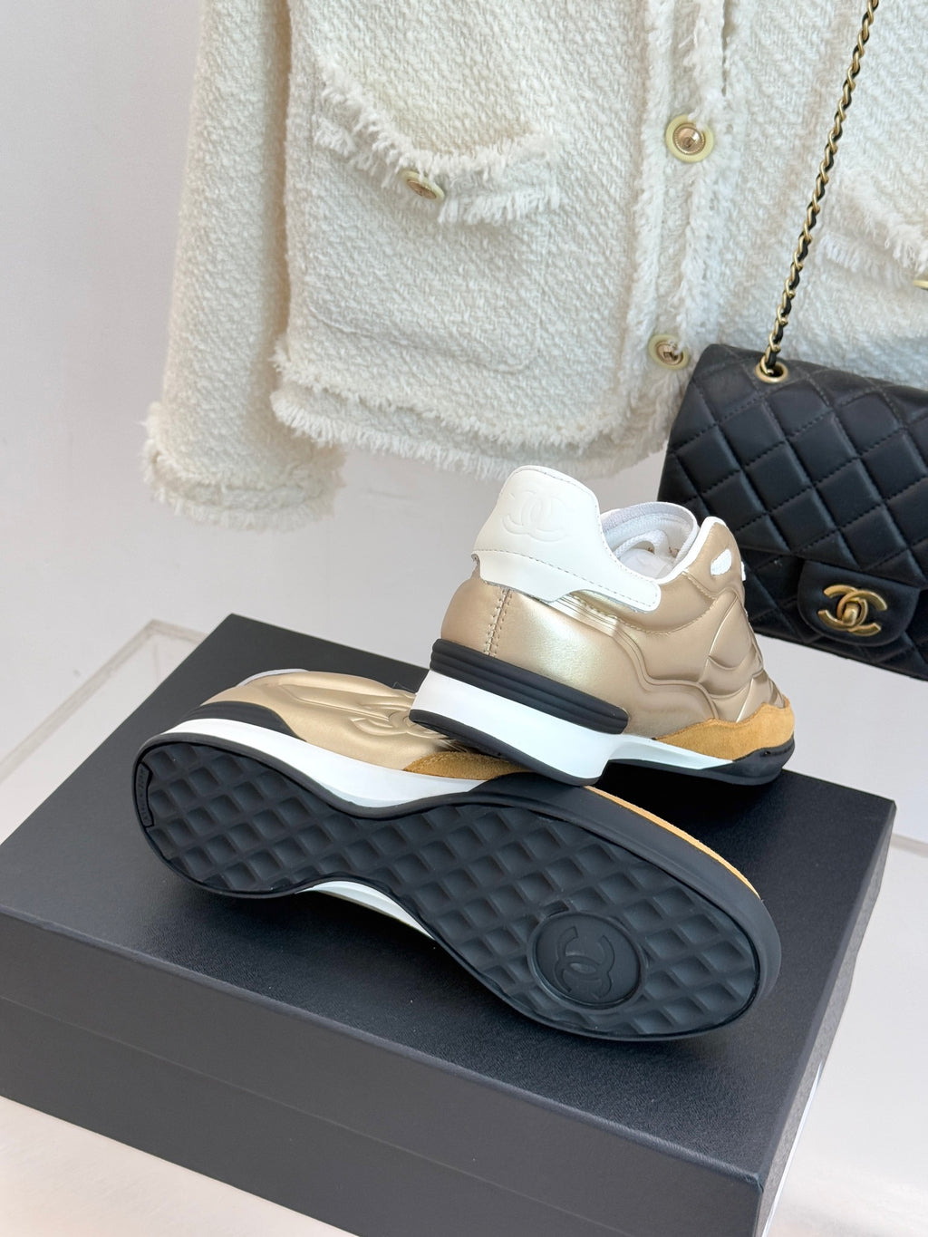 Chanel sneaker bottom view in gold with textured dark rubber sole