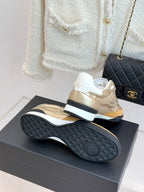 Chanel sneaker bottom view in gold with textured dark rubber sole
