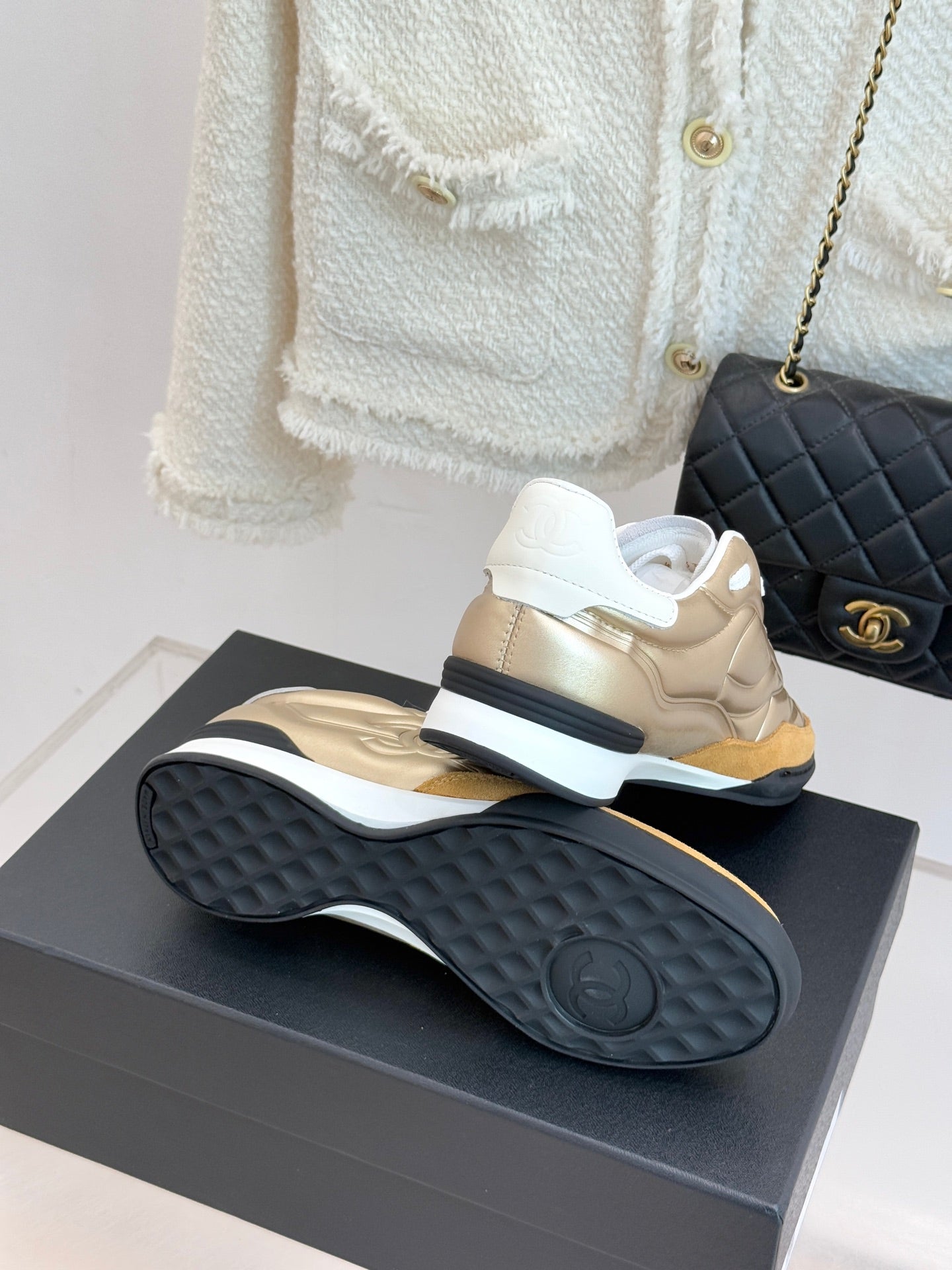 Chanel sneaker bottom view in gold with textured dark rubber sole