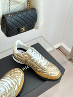 Chanel low-top sneakers with gold leather uppers and white lace-up panels
