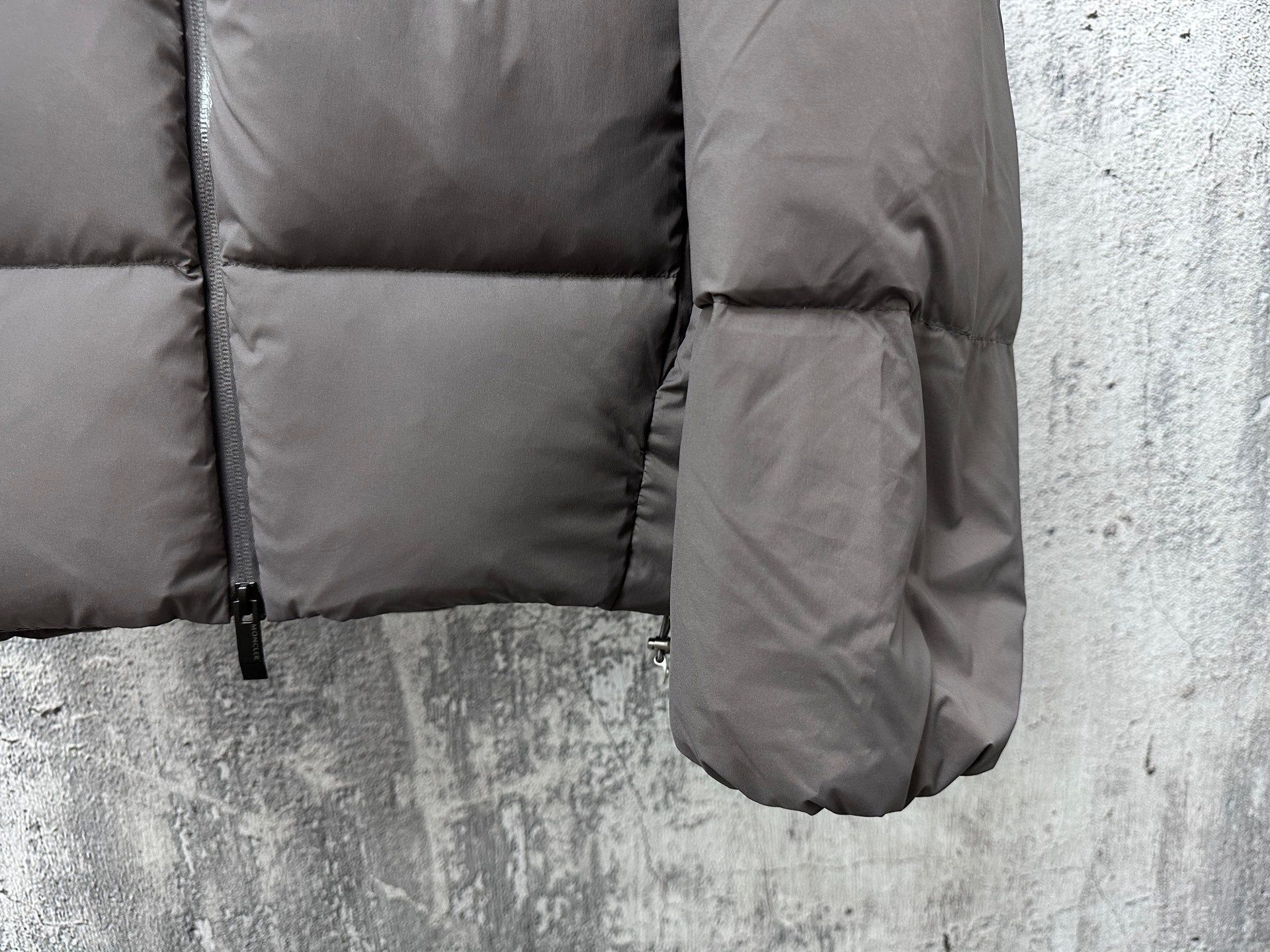 Long padded jacket with front pocket opening and drawcord hem, dark gray