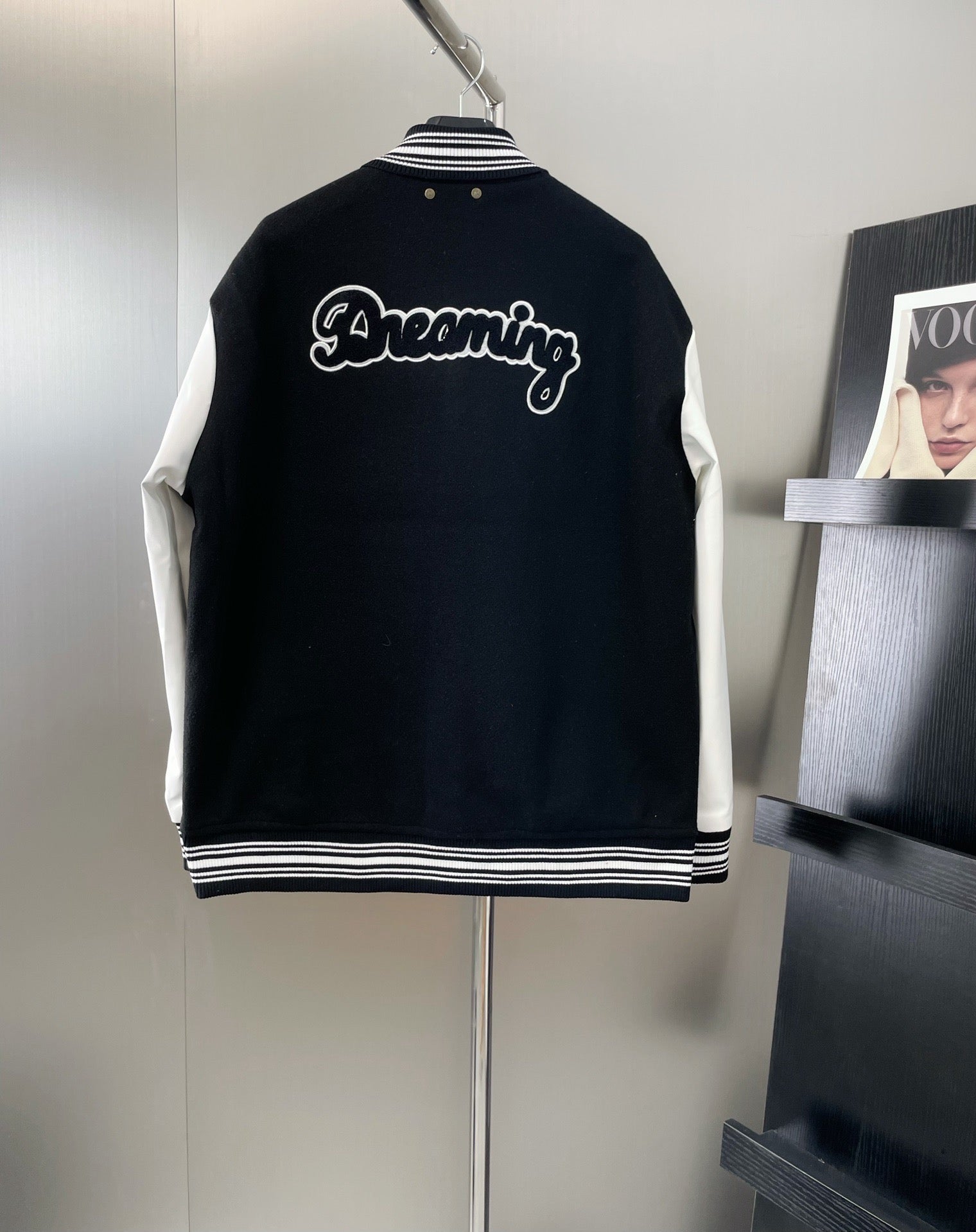 Louis Vuitton long varsity jacket, back view in black with white script “Dreaming”
