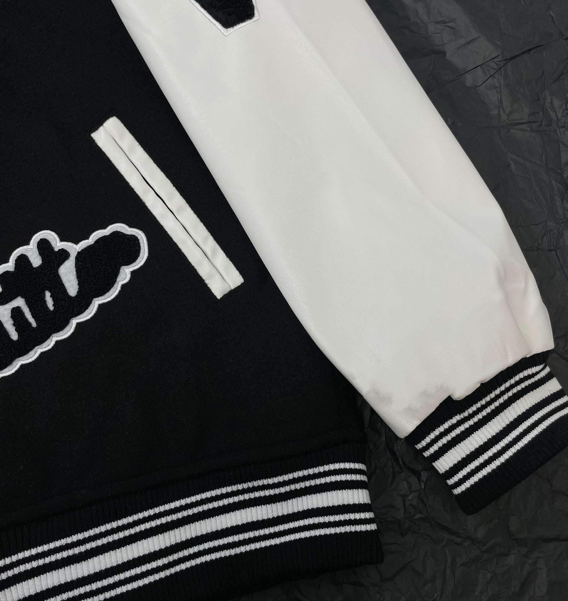Louis Vuitton long varsity jacket sleeve cuff close-up, white panel with striped ribbed hem
