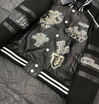 Louis Vuitton leather-look varsity jacket laid flat with front patch graphics and striped cuffs