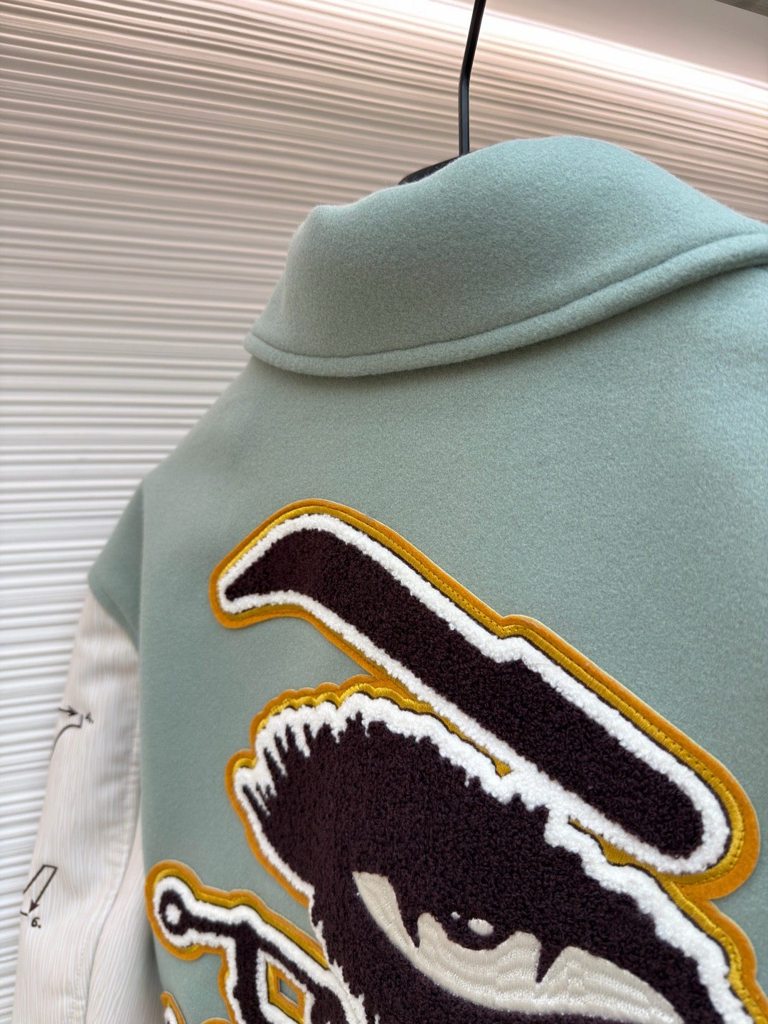 Light blue jacket back, animal-face embroidered patch with yellow-and-black outline