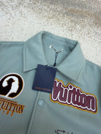 Light blue Louis Vuitton jacket with hang tag, colorful logo patch and snap buttons