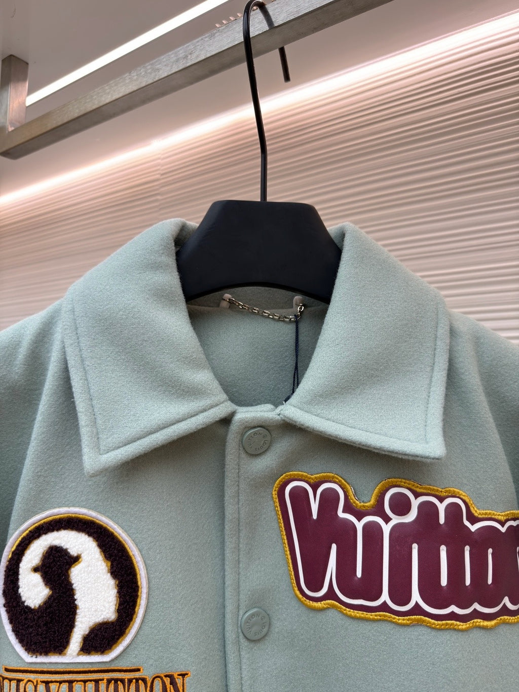Light blue jacket collar and front, embroidered patch on chest with buttoned placket
