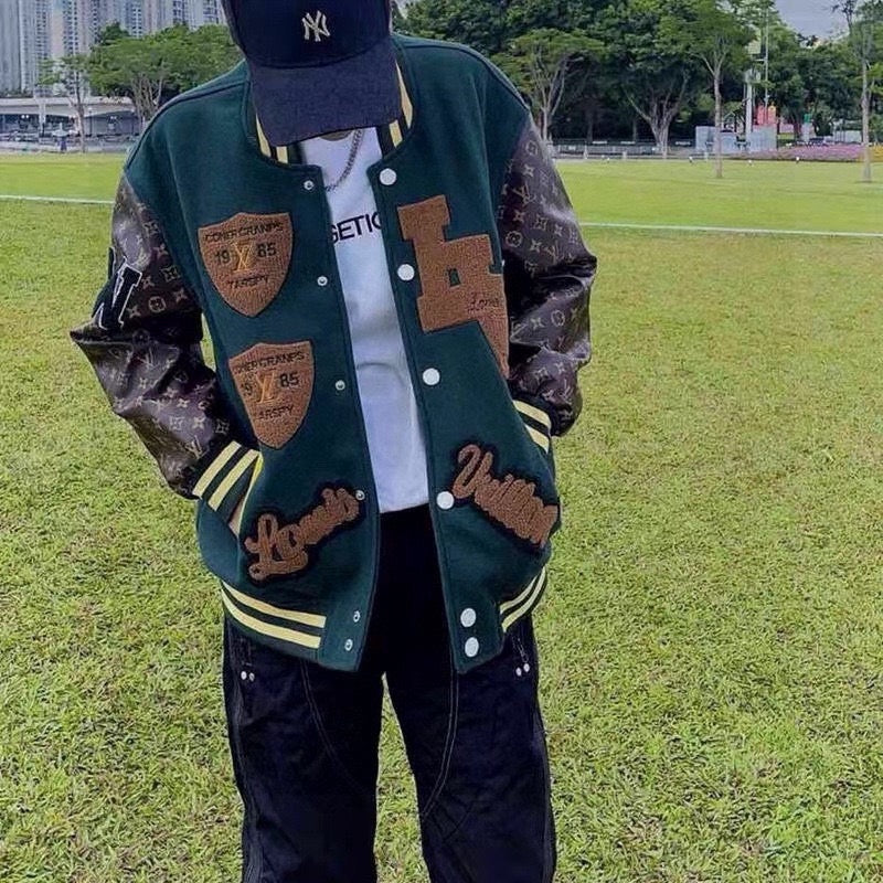 Green varsity jacket front view with button front, patches, and striped cuffs and collar