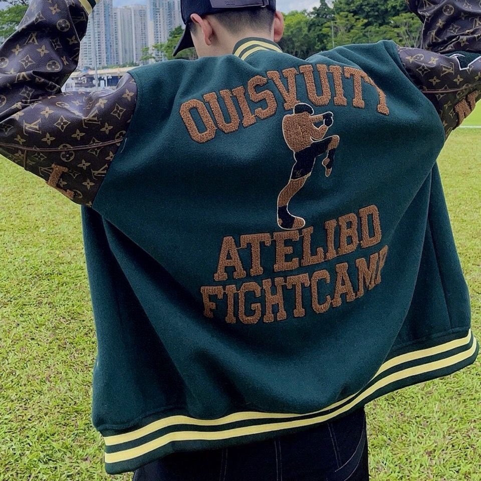 Back of green varsity jacket with large brown text and cat patch, striped hem and cuffs