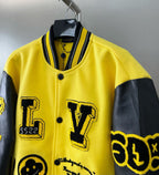 Yellow Louis Vuitton jacket with ribbed striped trim, snap buttons, and large black letter patch