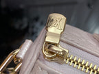 Louis Vuitton light pink bag close-up of gold clasp with LV emblem