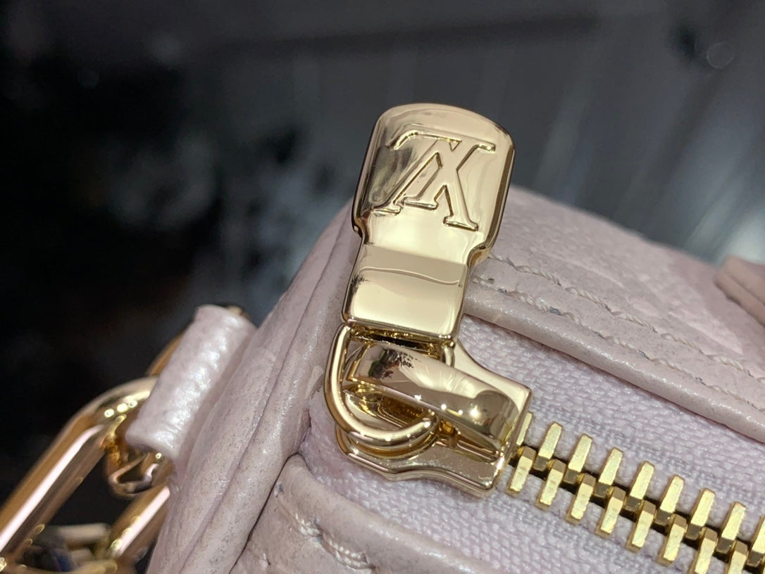 Louis Vuitton light pink bag close-up of gold clasp with LV emblem
