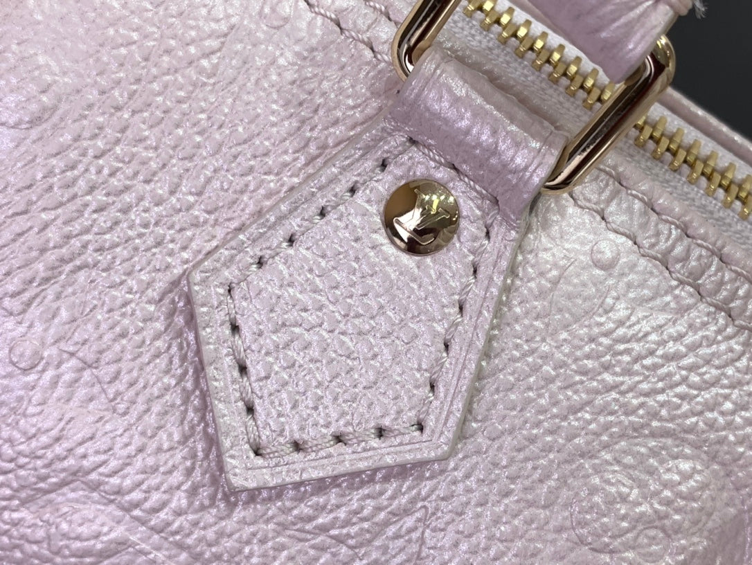 Louis Vuitton light pink bag close-up of embossed leather and stitched pocket detail