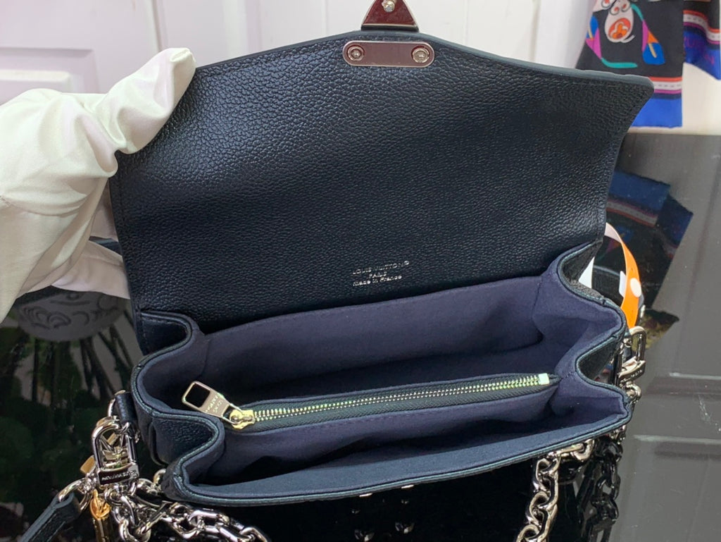 Dark teal flap bag interior with zipper pocket and gold-tone chain strap