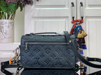 Dark teal monogram handbag with front flap, zipper pocket detail, and chain strap