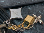Padlock and bow charms on chain with embossed dark teal leather bag backing
