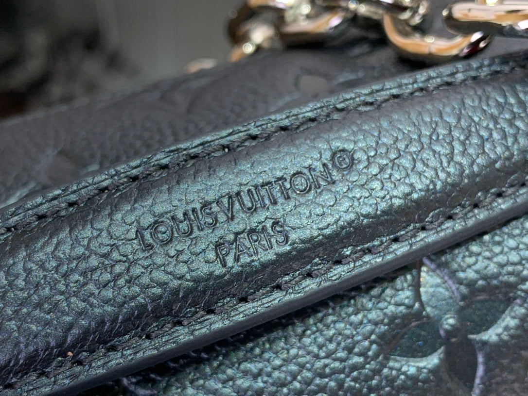 Embossed leather strap close-up with 'LOUIS VUITTON' text and visible stitching