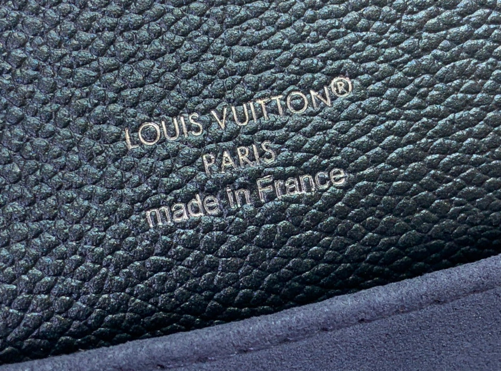 Embossed logo text on dark teal pebbled leather: 'LOUIS VUITTON' and 'made in France'