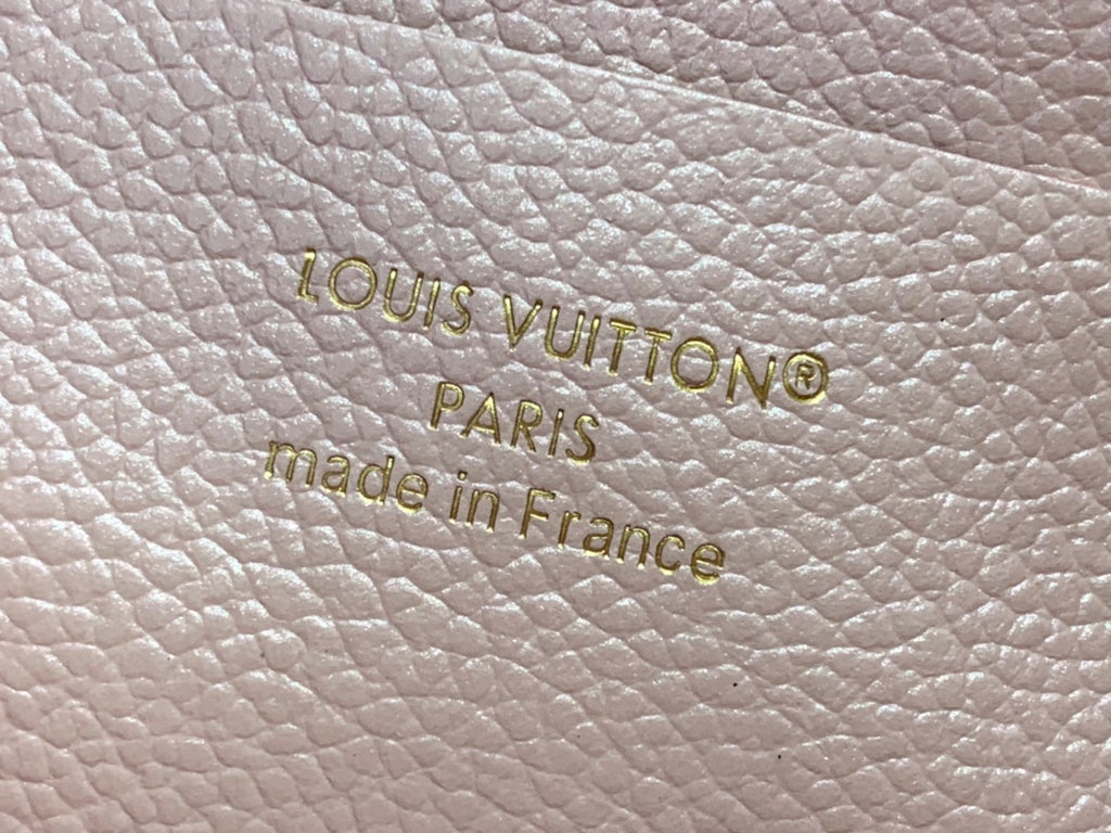 Embossed Louis Vuitton Paris and Made in France on light pink textured leather.