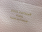 Embossed Louis Vuitton Paris and Made in France on light pink textured leather.