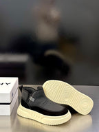 Open side view: dark gray slip-on sneaker with light patterned sole and cream tread.