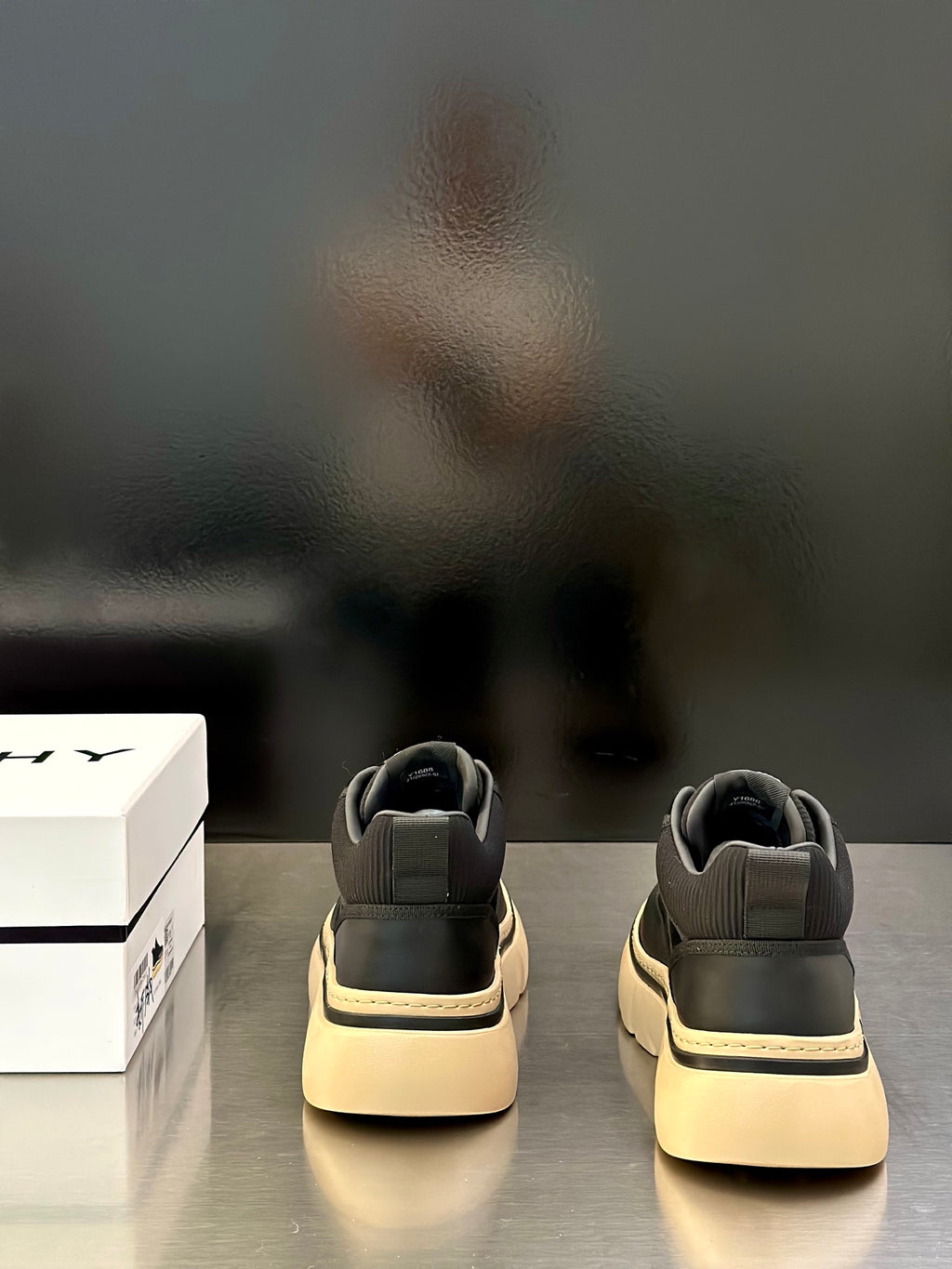Back view of black Givenchy sneakers with heel tabs and cream soles
