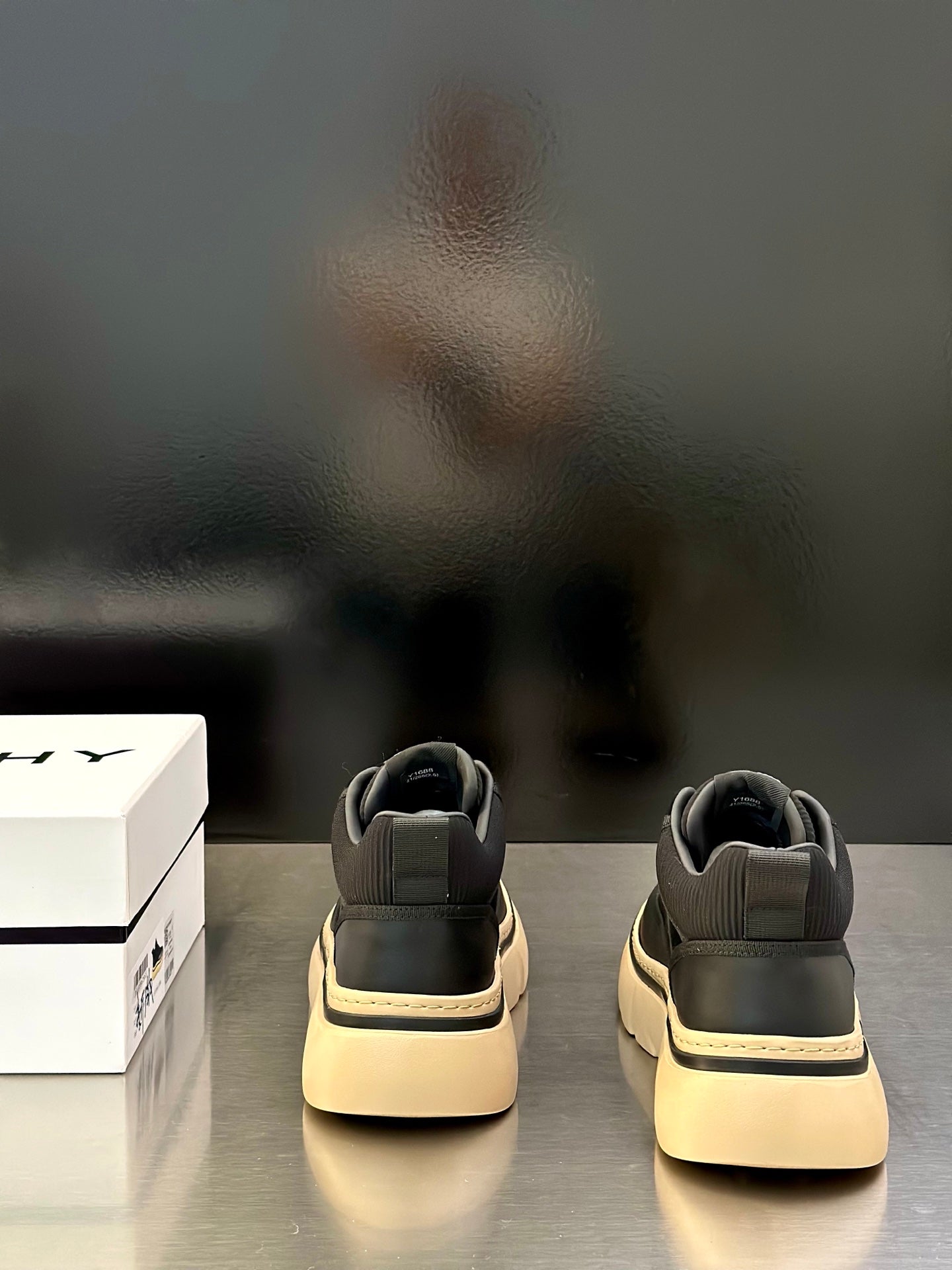 Back view of black Givenchy sneakers with heel tabs and cream soles