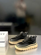 Black Givenchy sneakers with lace-up detailing, logo patch, and cream sole trim