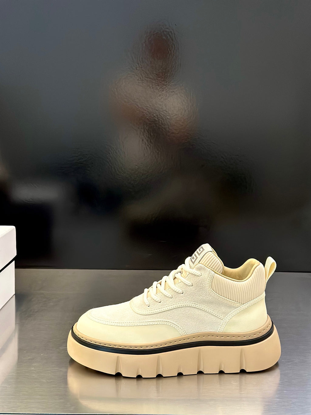 Givenchy cream low-top sneakers on display, lace-up front with logo patch and platform sole